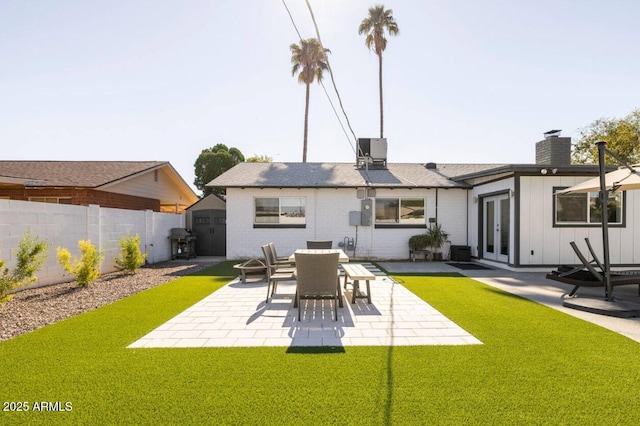 back of property with central AC unit, a storage unit, a patio area, and french doors