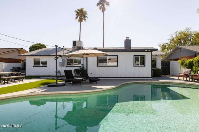 back of house featuring a fenced in pool and a patio