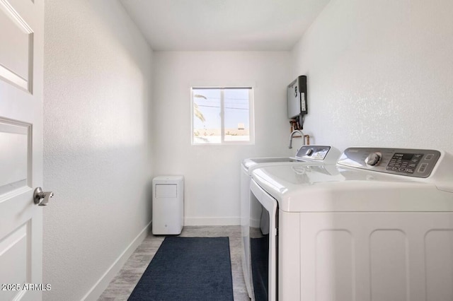 washroom with light hardwood / wood-style floors and washing machine and clothes dryer