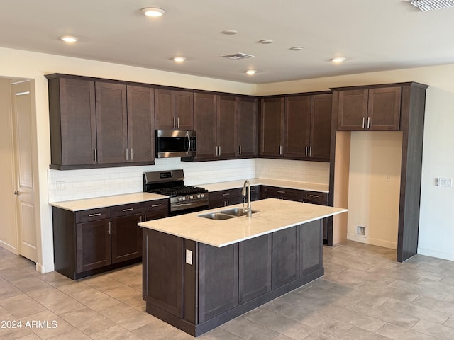 kitchen featuring decorative backsplash, sink, an island with sink, and appliances with stainless steel finishes