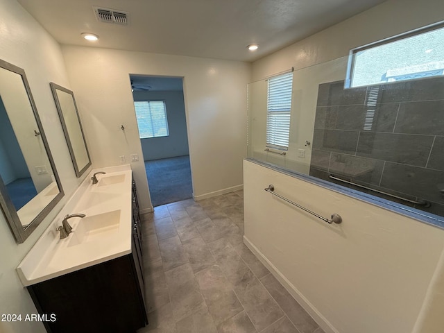 bathroom with vanity and tiled shower