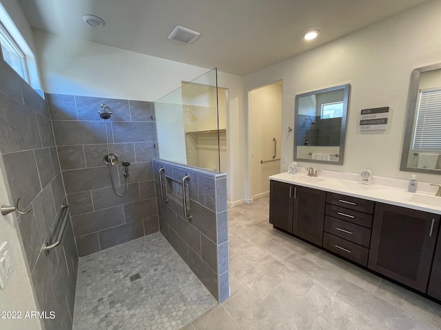 bathroom with tiled shower, vanity, and tile patterned floors