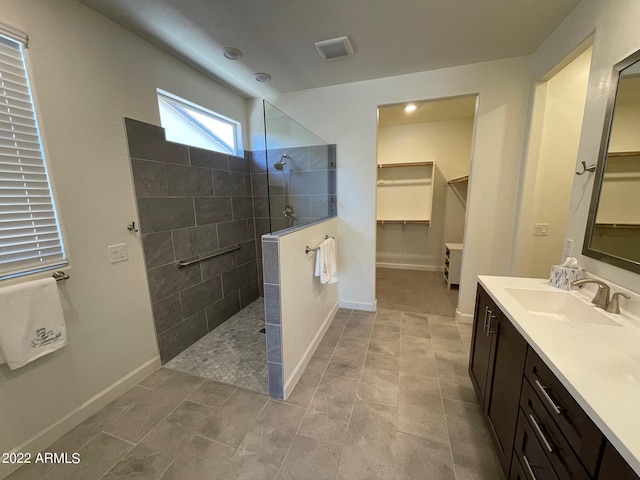 bathroom with vanity and tiled shower