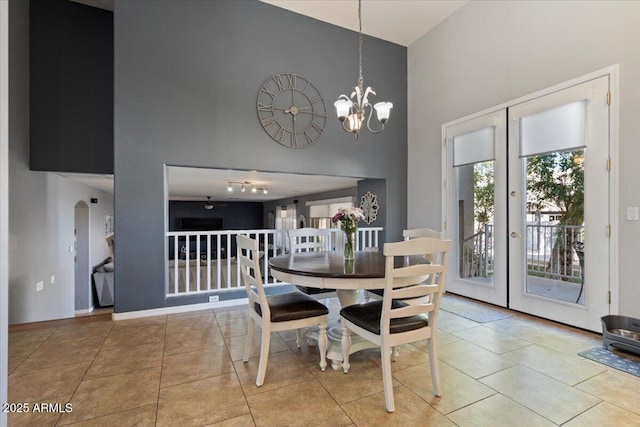 tiled dining area featuring french doors and a notable chandelier