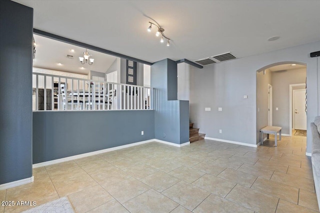 unfurnished room featuring a chandelier