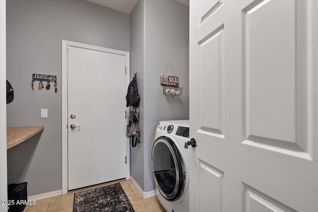 clothes washing area with washer / clothes dryer and light tile patterned floors