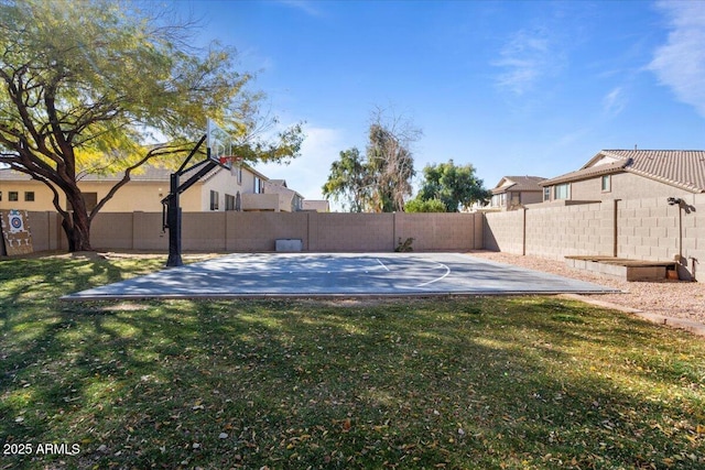 view of sport court with a yard