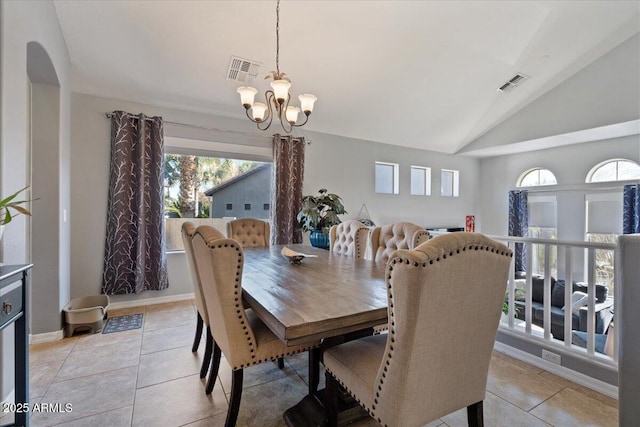 dining room with a notable chandelier, lofted ceiling, and light tile patterned floors