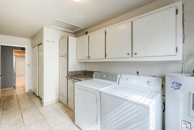 washroom with cabinet space, light tile patterned floors, attic access, independent washer and dryer, and electric water heater