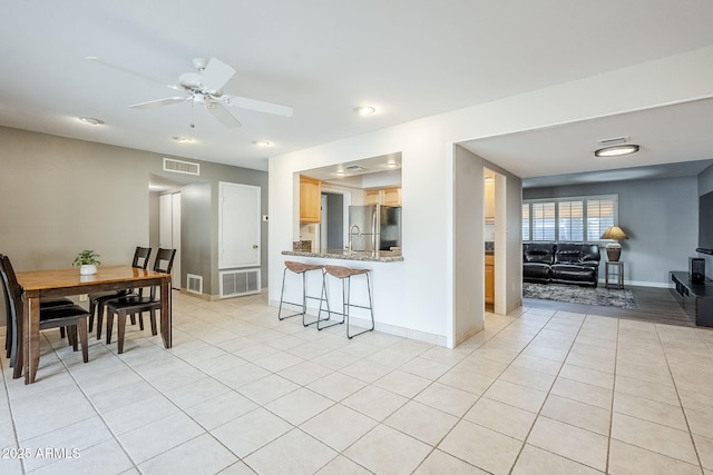 interior space with freestanding refrigerator, visible vents, and light tile patterned floors