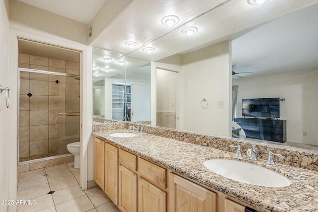 bathroom featuring tile patterned floors, a sink, toilet, and a shower stall