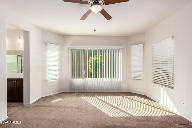 spare room featuring light colored carpet and ceiling fan