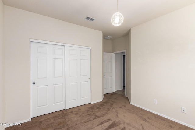 unfurnished bedroom with a closet and carpet floors