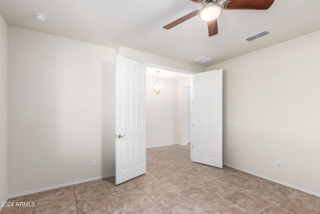 unfurnished room with light tile patterned floors and ceiling fan