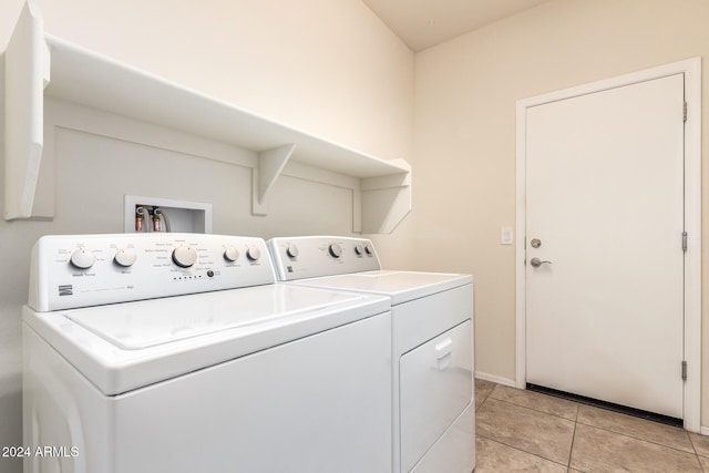 clothes washing area featuring washing machine and clothes dryer and light tile patterned floors