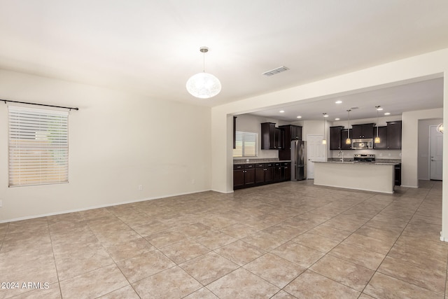 unfurnished living room featuring a healthy amount of sunlight and light tile patterned floors