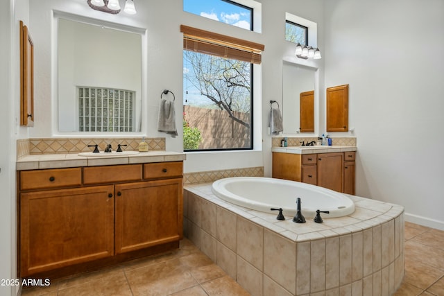 full bathroom featuring tasteful backsplash, a garden tub, a sink, and tile patterned floors