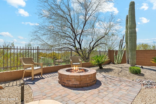 view of patio featuring fence and a fire pit