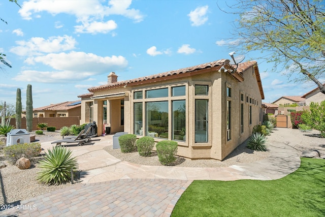 back of house with a patio area, fence, a chimney, and stucco siding