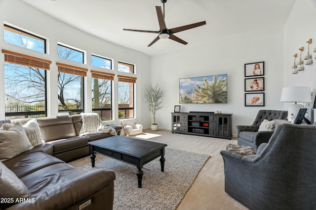 living room featuring ceiling fan, light wood-style flooring, and baseboards