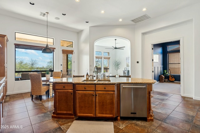 kitchen with arched walkways, visible vents, a sink, and stainless steel dishwasher