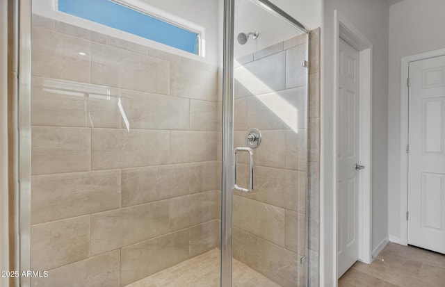 bathroom featuring a shower with door