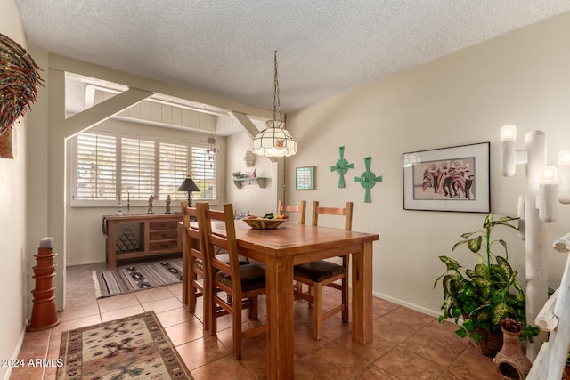 tiled dining room with a textured ceiling