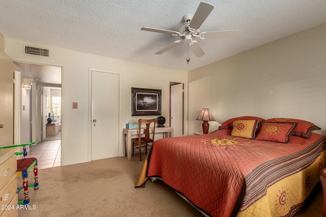 carpeted bedroom with ceiling fan and a textured ceiling