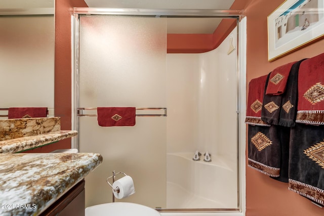 bathroom with vanity, toilet, and a shower with shower door