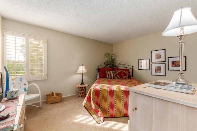 bedroom with light carpet and a textured ceiling