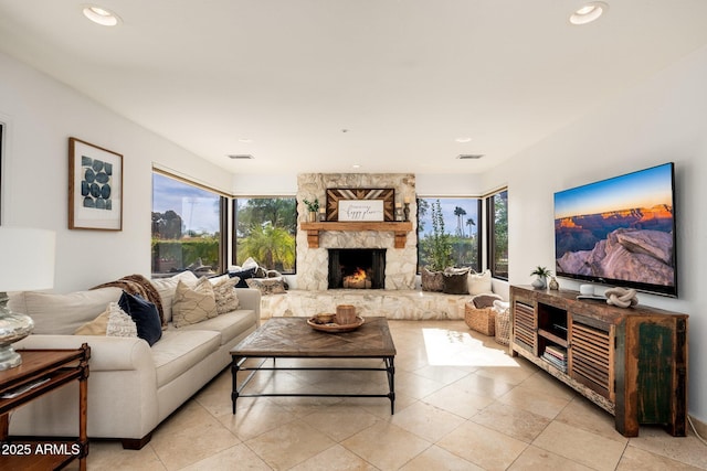 living room featuring a fireplace, plenty of natural light, and light tile patterned flooring