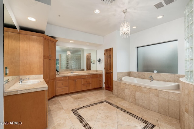 bathroom with a chandelier, vanity, a relaxing tiled tub, and tile patterned floors