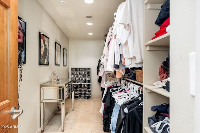 walk in closet with light tile patterned floors