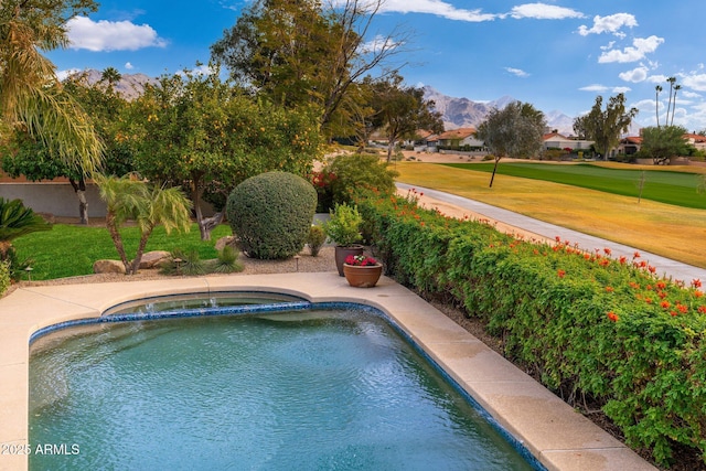 view of swimming pool featuring a mountain view, a yard, and an in ground hot tub