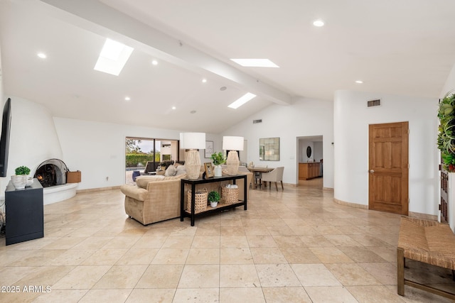 living room with a skylight, a fireplace, beamed ceiling, and high vaulted ceiling