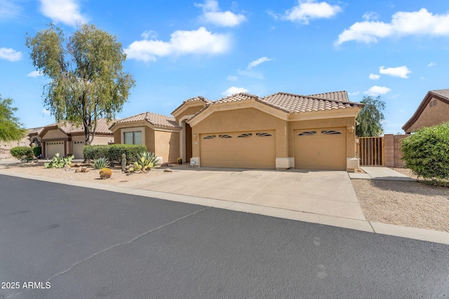 view of front of property with an attached garage, stucco siding, a tiled roof, and concrete driveway