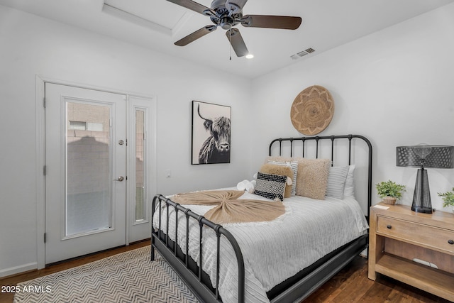 bedroom featuring ceiling fan, visible vents, and wood finished floors