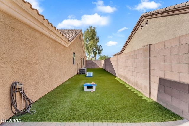 view of yard with central air condition unit and a fenced backyard