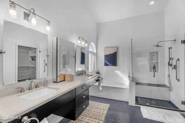 full bathroom with double vanity, a sink, a bath, and a stall shower