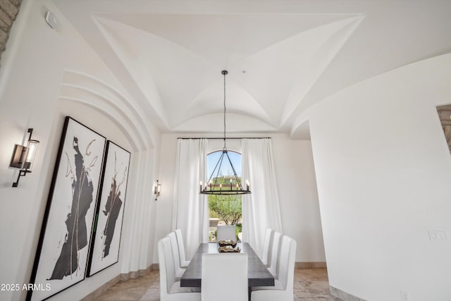 dining space featuring a chandelier, baseboards, marble finish floor, and vaulted ceiling
