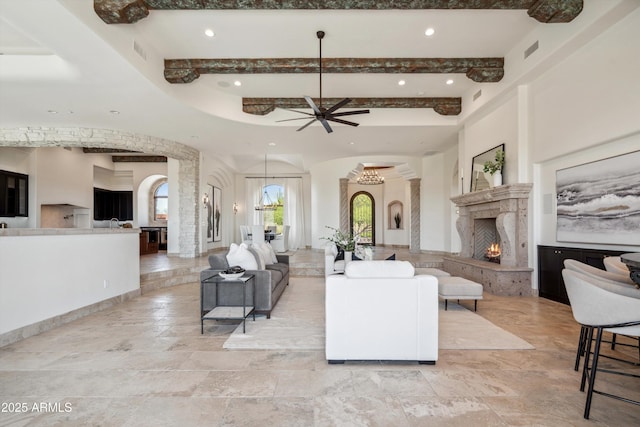living room featuring recessed lighting, a ceiling fan, beamed ceiling, and arched walkways