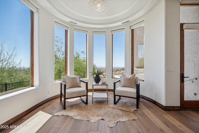 living area with visible vents and wood finished floors