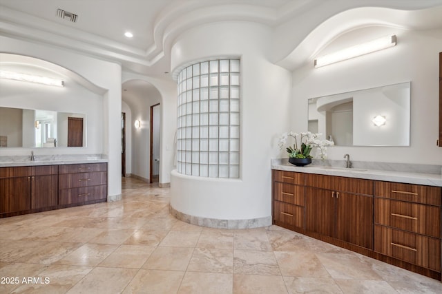 bathroom with two vanities, visible vents, marble finish floor, and a sink