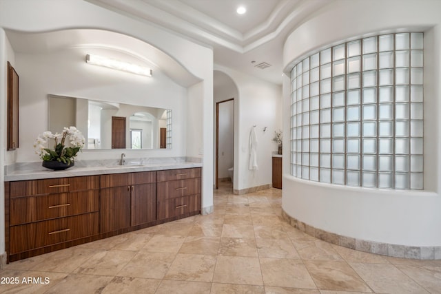 bathroom with toilet, visible vents, and vanity