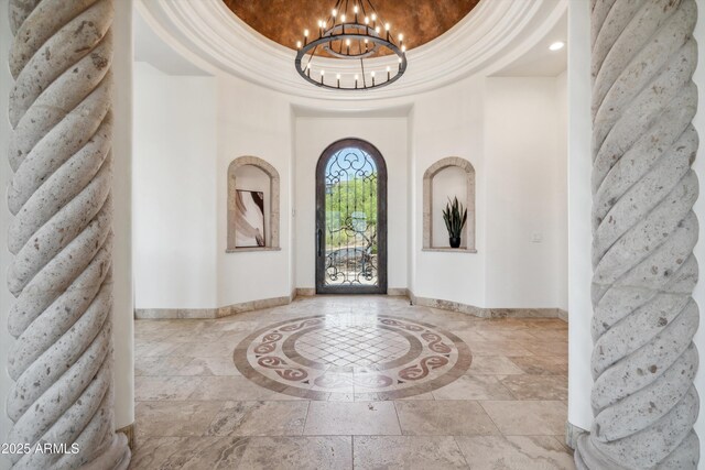entryway with a chandelier, recessed lighting, stone tile flooring, and baseboards