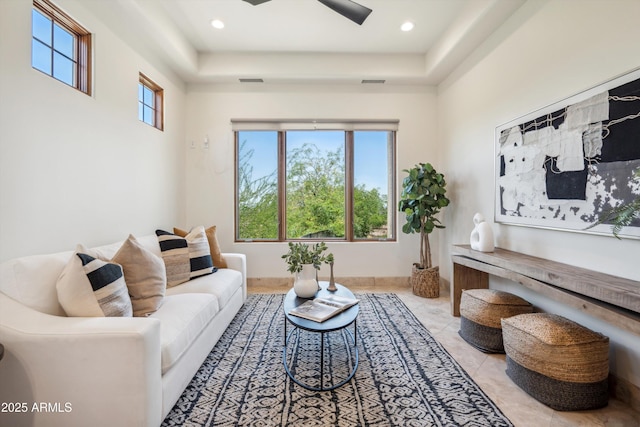 living area featuring recessed lighting, visible vents, and a tray ceiling