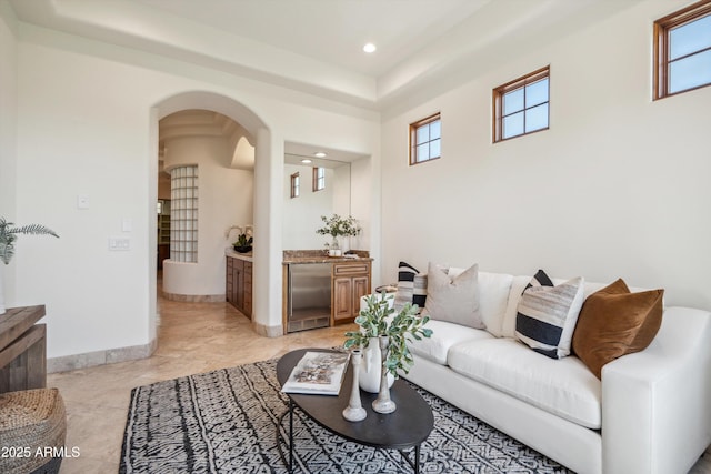 living area with plenty of natural light, baseboards, recessed lighting, and arched walkways
