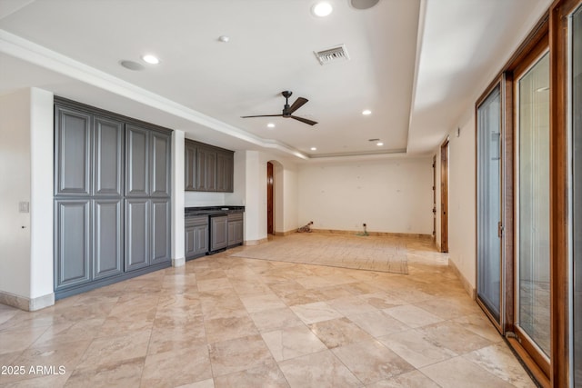 unfurnished living room with visible vents, ceiling fan, a tray ceiling, arched walkways, and recessed lighting