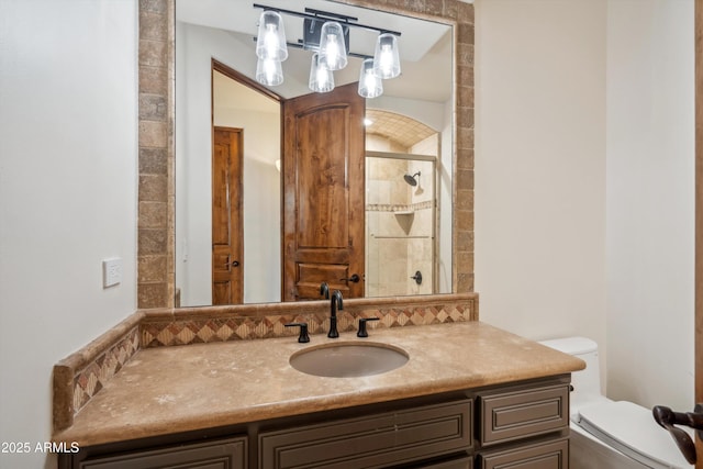 bathroom with a shower stall, toilet, and vanity