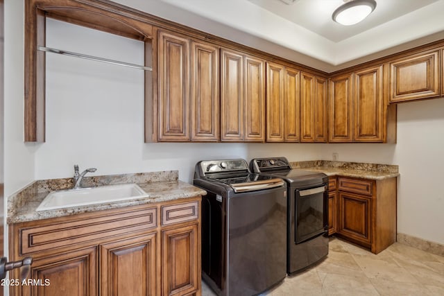 laundry area featuring washer and dryer, a sink, and cabinet space